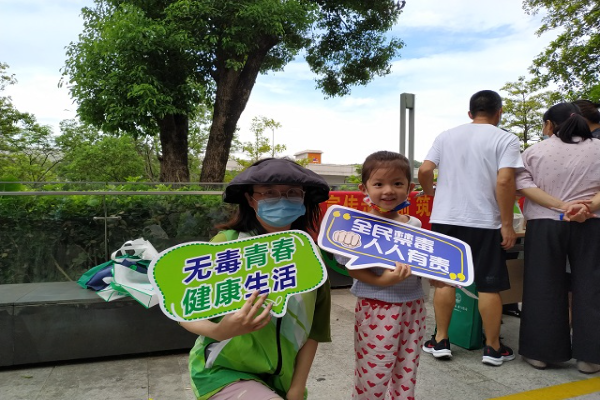 圖為禁毒社工與社區居民手持禁毒標語KT板合影2.jpg