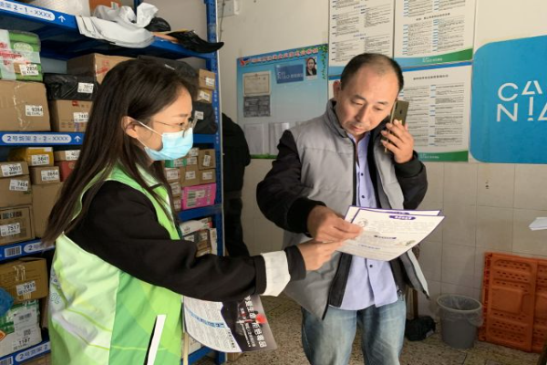 圖為寄遞從業人員閱讀宣傳資料.jpg