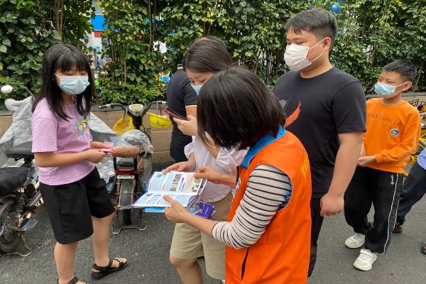 給排隊的居民派發宣傳手冊并講解禁毒知識1.jpg