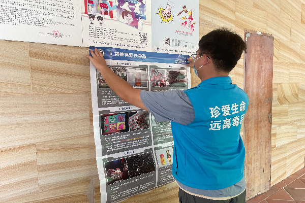 禁毒社工在人流量多的地方粘貼禁毒宣傳海報.jpg